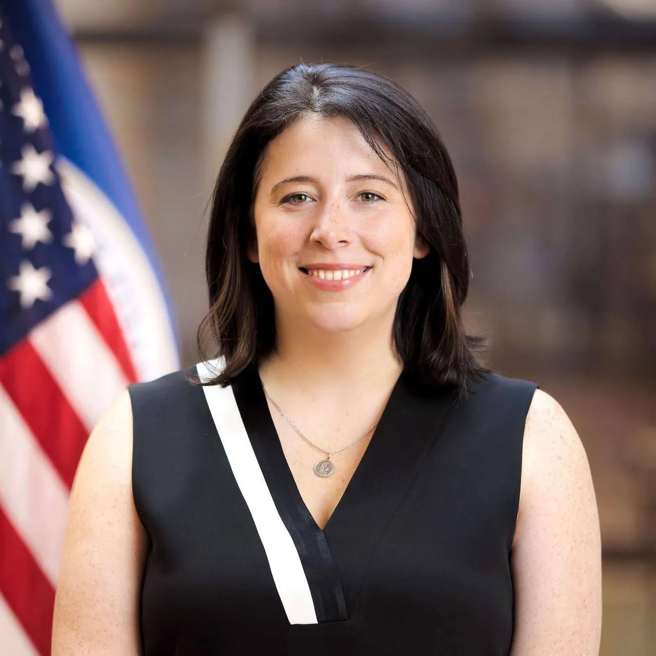 Erie Meyer smiling in front of an American flag.