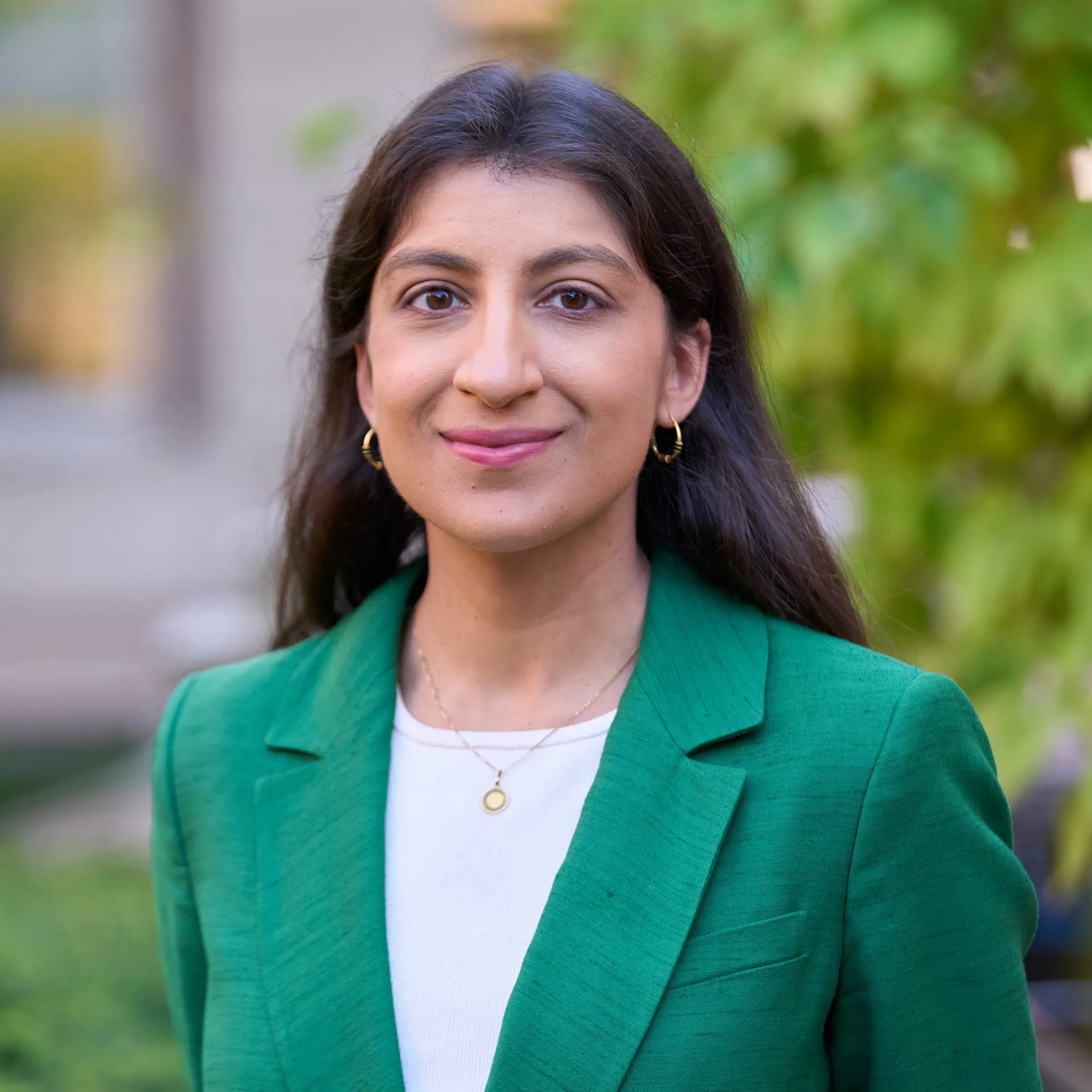 Lina Khan smiling in front of Columbia Law School.