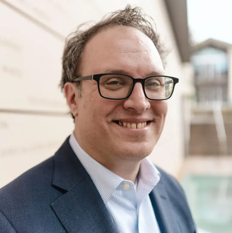 Seth Frotman smiling in front of a building